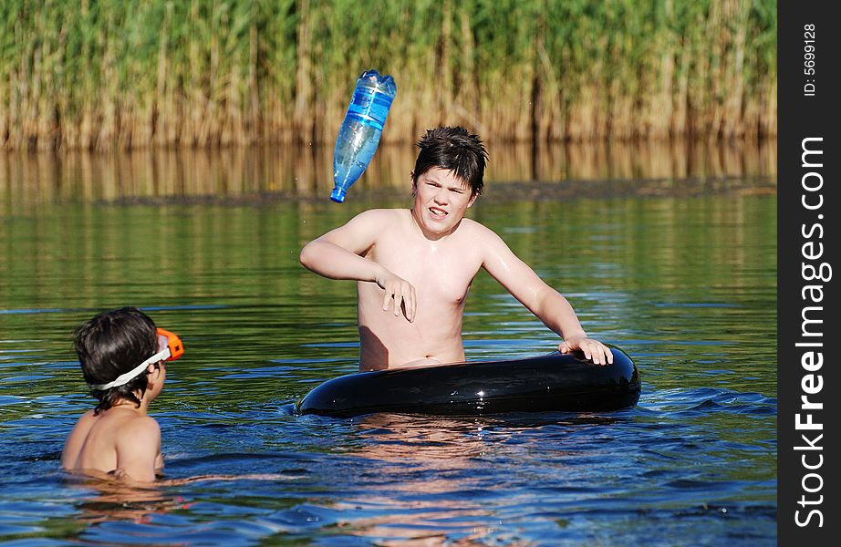 The boy playing with his friend in a small Lithuanian lake. The boy playing with his friend in a small Lithuanian lake.