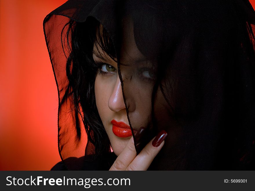 Portrait of young nice woman in black veil on red back. Portrait of young nice woman in black veil on red back