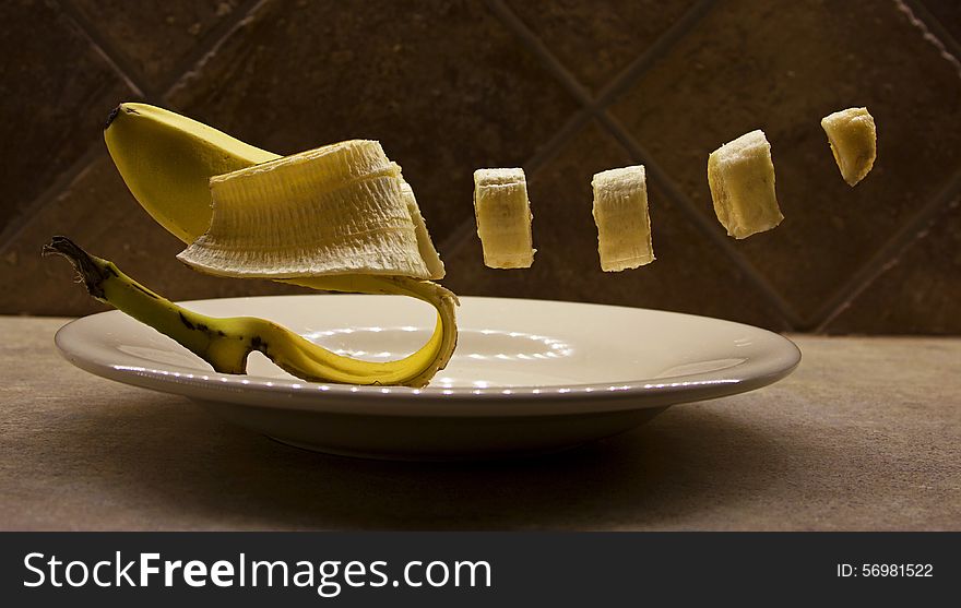 A sliced banana levitating above a plate. A sliced banana levitating above a plate