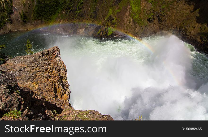 A rainbow that formed at the bottom of a waterfall in Yellowstone National Park. A rainbow that formed at the bottom of a waterfall in Yellowstone National Park