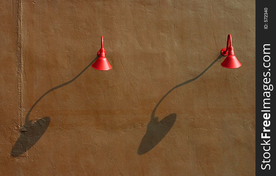Two red lights on brown wall