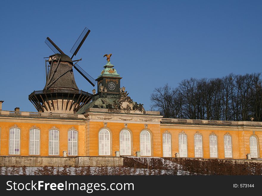 Historical windmill with the Orangerie Castle in the garden of Sanssouci in winter