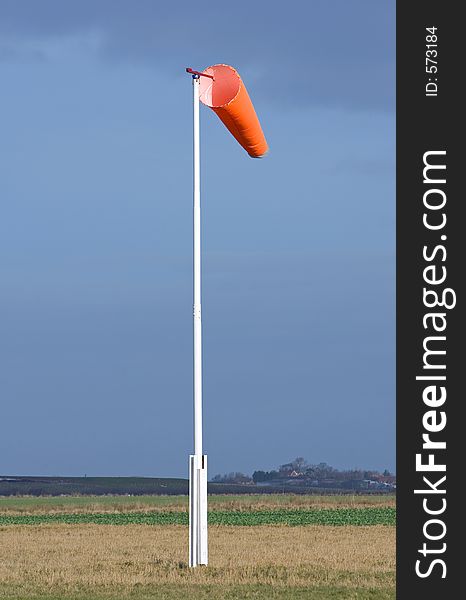 Wind sock in field of skydiving drop zone at Langar Airfield in Nottinghamshire on a dark, moody day