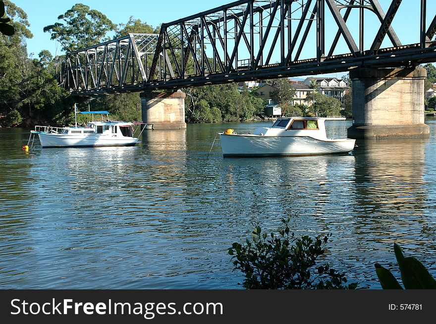 Two boats moored under the bridge