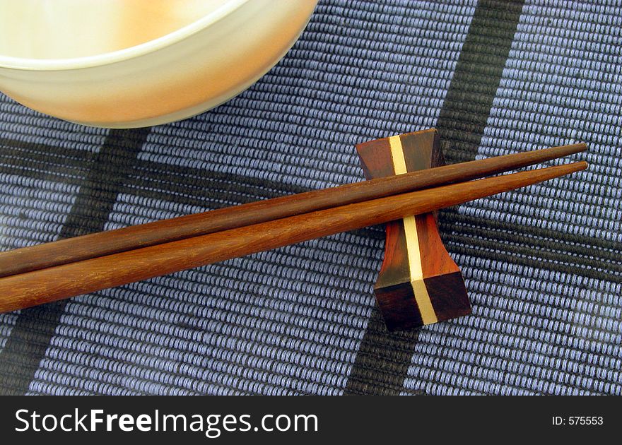 Chopsticks and bowl on a blue mat