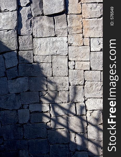 Deep sunny shadows on a large tiled stone wall. Deep sunny shadows on a large tiled stone wall