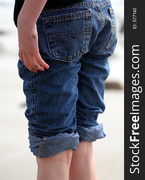 Child who is all sandy with rolled up jeans. Child who is all sandy with rolled up jeans.