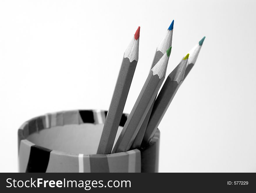 Black and white pencils in a pot with coloured tips, one tip out of focus rest are in focus