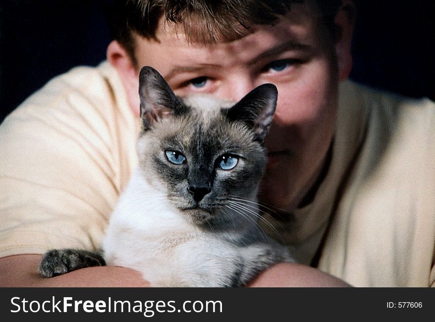 Teenage boy and Siamese cat. Teenage boy and Siamese cat.