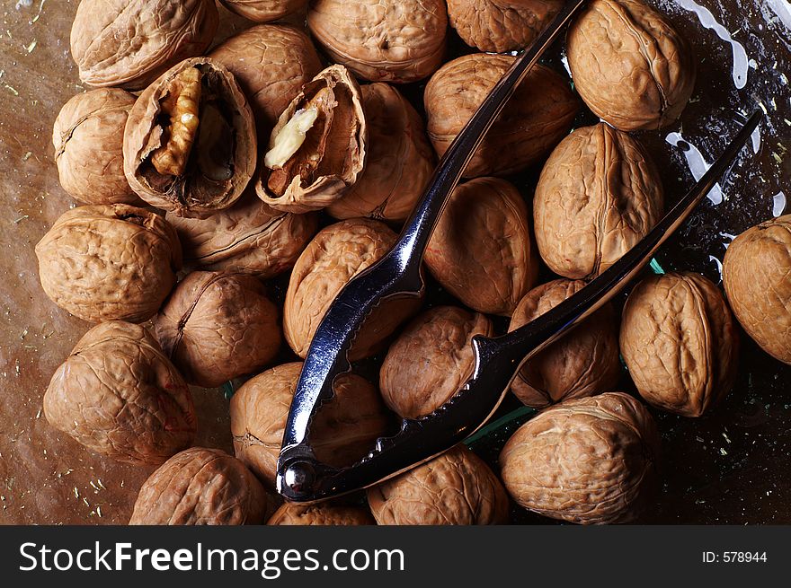 Walnuts and a cracker on a glass plate. One nut open. Walnuts and a cracker on a glass plate. One nut open.