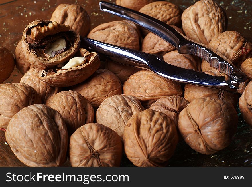 Walnuts and a cracker on a glass plate. One nut open. Walnuts and a cracker on a glass plate. One nut open.