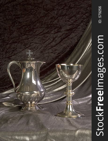 Silver chalice and ewer used for communion photographed in verticle format. Silver chalice and ewer used for communion photographed in verticle format