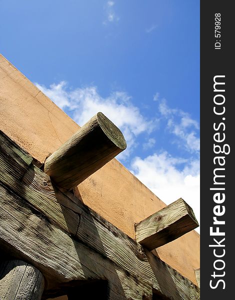 Broad sky and partial view of an adobe and timber building. Broad sky and partial view of an adobe and timber building.