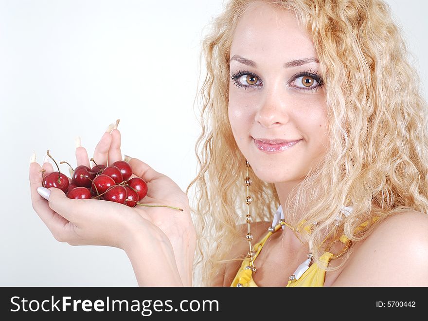 Beauty woman with red cherry in hands at white background