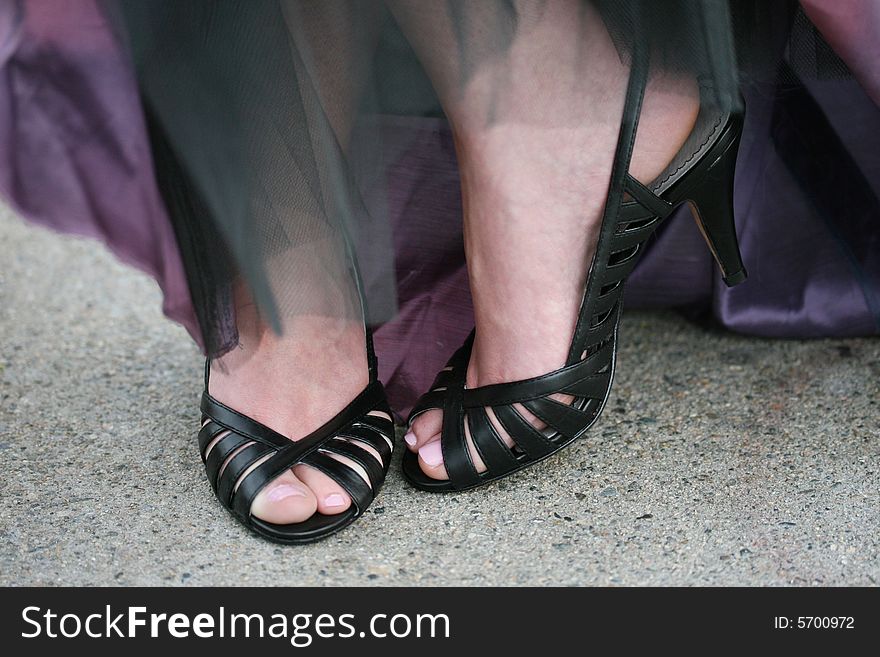 A woman in black high heels and an evening gown