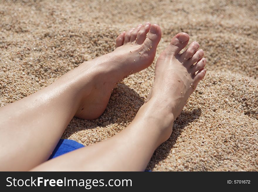 A photo of women's feet on the sand