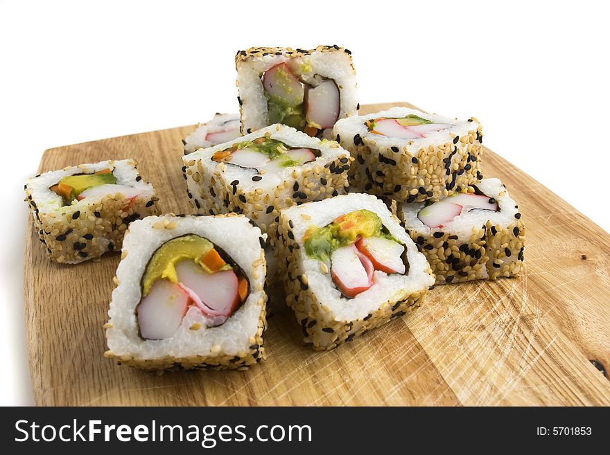 Sushi slices on a wooden board on white background. Sushi slices on a wooden board on white background