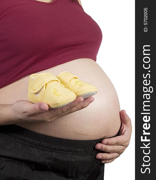 A pregnant women show her tummy with yellow shoe
