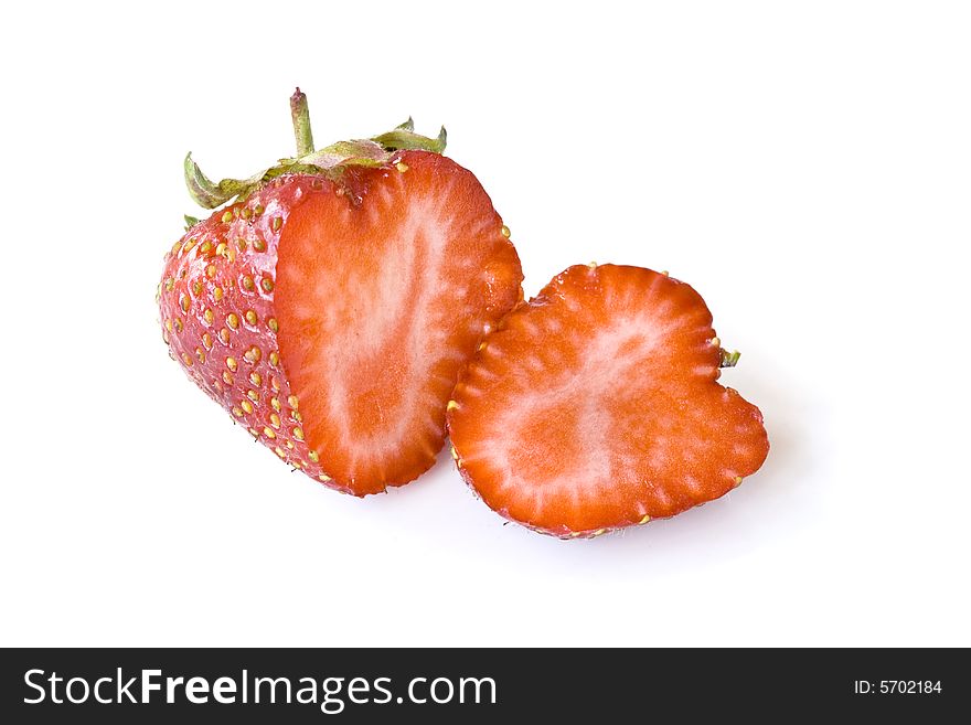 The increased image of a strawberry. The berry cut displays internal structure of a fruit.