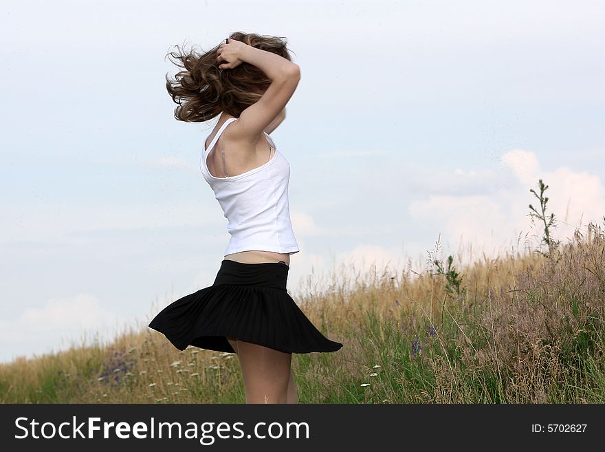 A beautiful girl dancing on the field. A beautiful girl dancing on the field