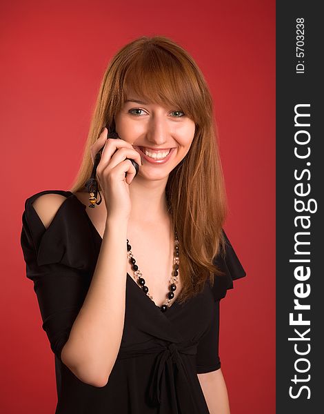 Smiling girl in evening dress calling on phone. Smiling girl in evening dress calling on phone