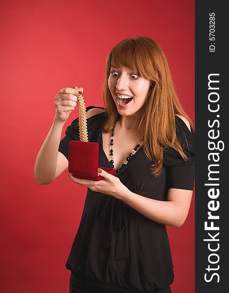 Shocked girl with present isolated on red background. Shocked girl with present isolated on red background