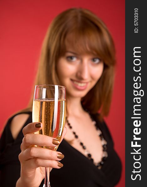 Girl with champagne, focus on glass, isolated on red background. Girl with champagne, focus on glass, isolated on red background