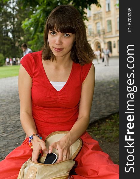 A beautiful young college girl putting stuff into her purse. A beautiful young college girl putting stuff into her purse