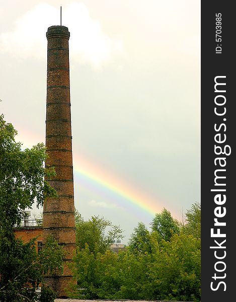 Old pipe of factory with a rainbow