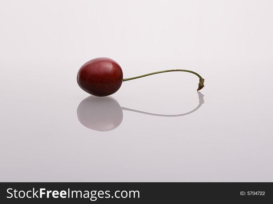 Cherry with tail on bluish backgroud. Cherry with tail on bluish backgroud