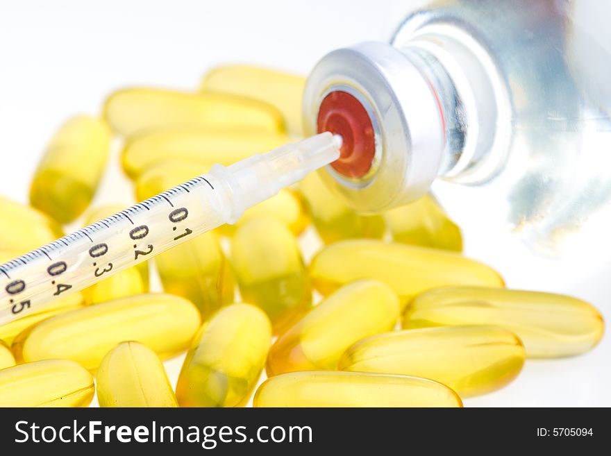 Three yellow pills, a syringe and medicine bottle. Three yellow pills, a syringe and medicine bottle.