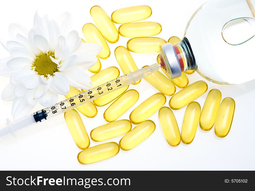 Three yellow pills, a syringe and medicine bottle. Three yellow pills, a syringe and medicine bottle.