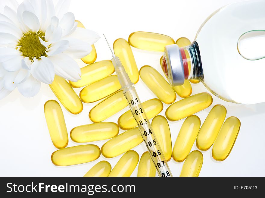 Three yellow pills, a syringe and medicine bottle. Three yellow pills, a syringe and medicine bottle.