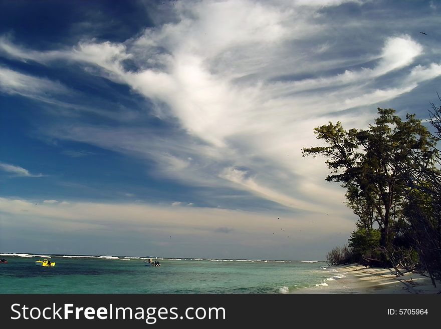 This is the morning lighted clouds, wild coast , waiting boats and sand beach . This is the morning lighted clouds, wild coast , waiting boats and sand beach .