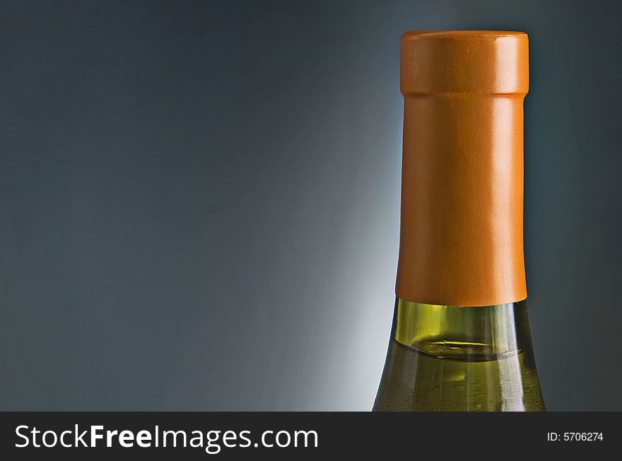 White wine bottle against dark gray background suitable for copy. White wine bottle against dark gray background suitable for copy