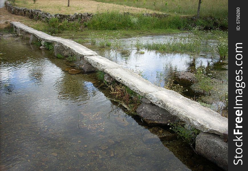 Stone bridge over a calm little river. Stone bridge over a calm little river