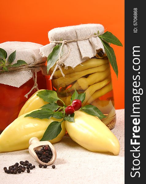 Marinated vegetables in glass jar, with fresh paprikas