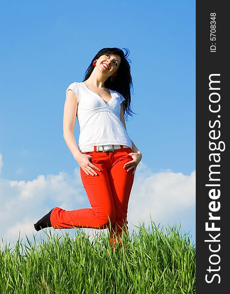 Pretty woman on green grass and sky background