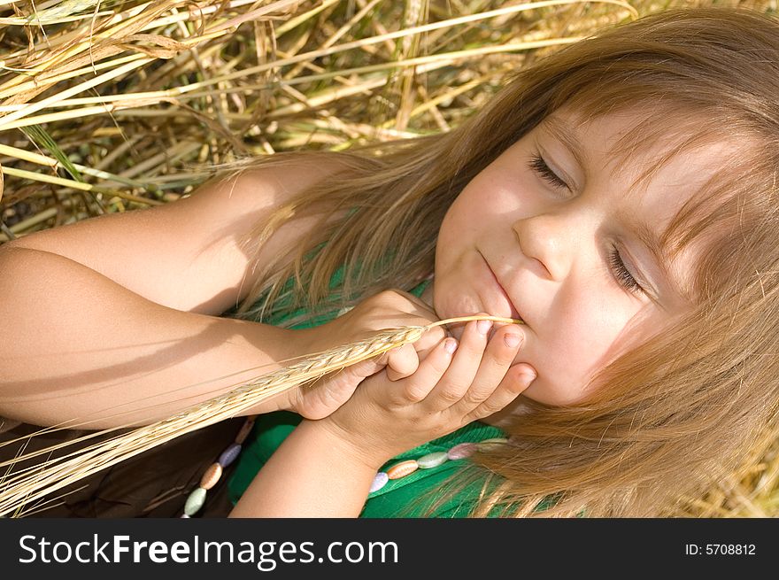 Little girl lying in the golden wheat field day dreaming. Little girl lying in the golden wheat field day dreaming