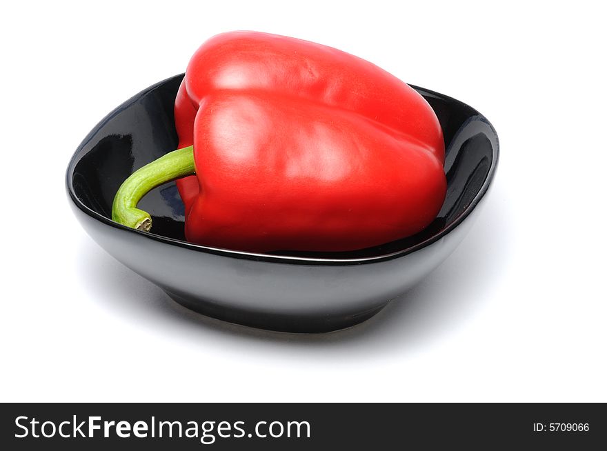 Red pepper on black dish isolated over white