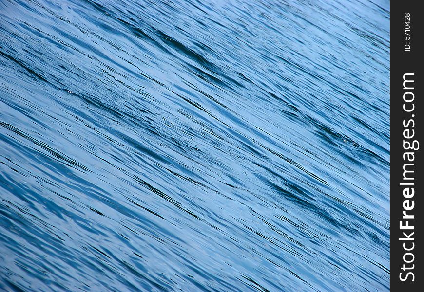 Blue, diagonal water waves as a background. Blue, diagonal water waves as a background.