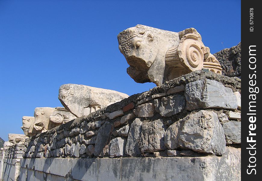 Old Roman carvings, high atop an ancient wall in the city of Ephesus, in early morning light. Old Roman carvings, high atop an ancient wall in the city of Ephesus, in early morning light.