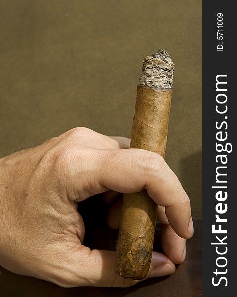 Man hand holding a lit cigar. Man hand holding a lit cigar