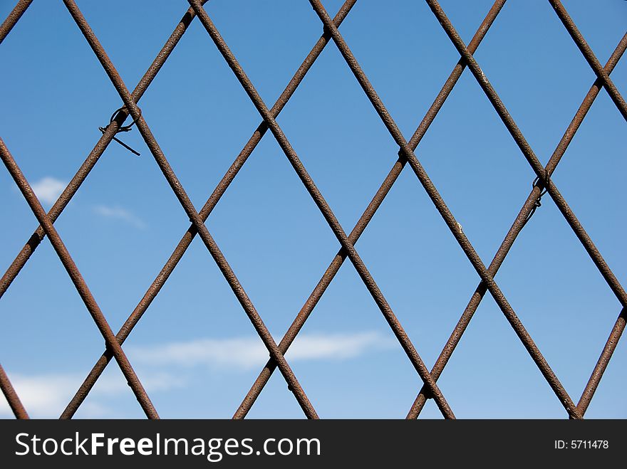 Rusty grate over sky background