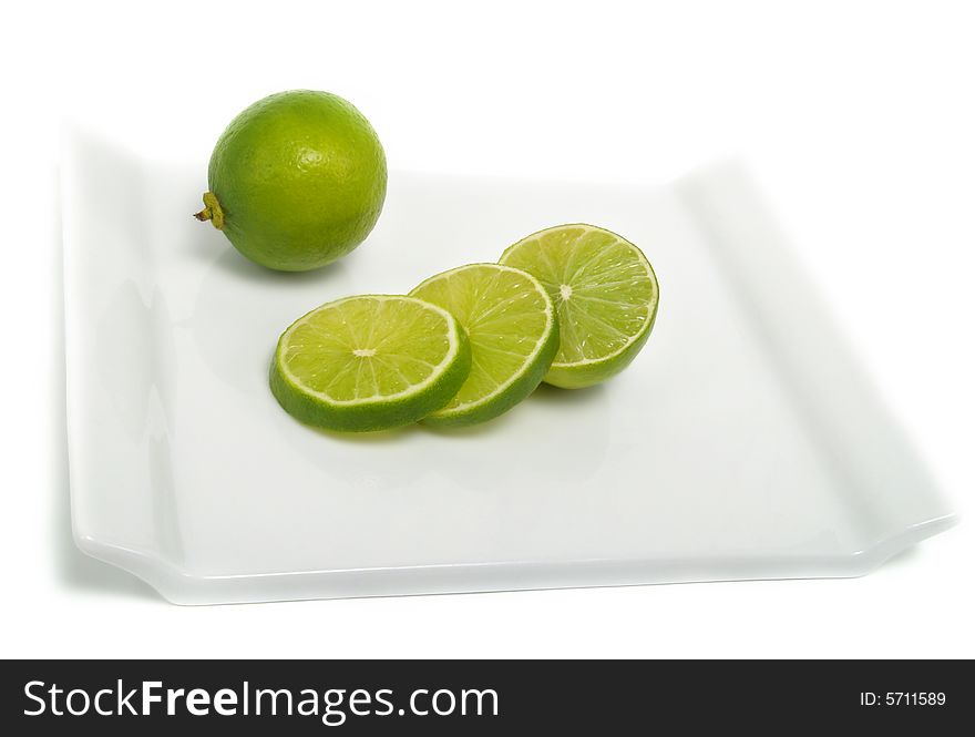 Sliced and whole fresh lime on cutting board and isolated on white background. Sliced and whole fresh lime on cutting board and isolated on white background