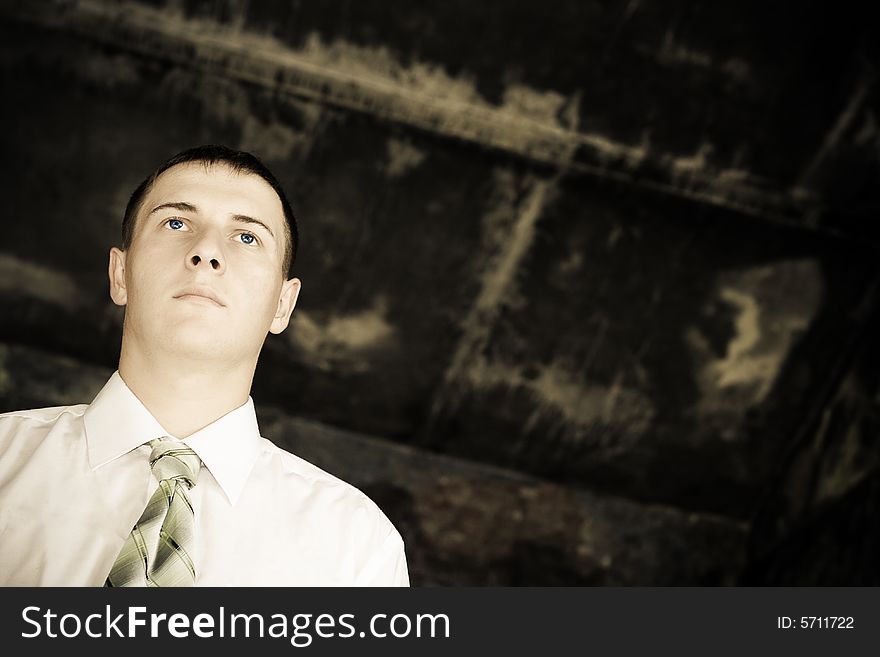 Young businessman looking far away, desaturated toned photo, copy space for the text