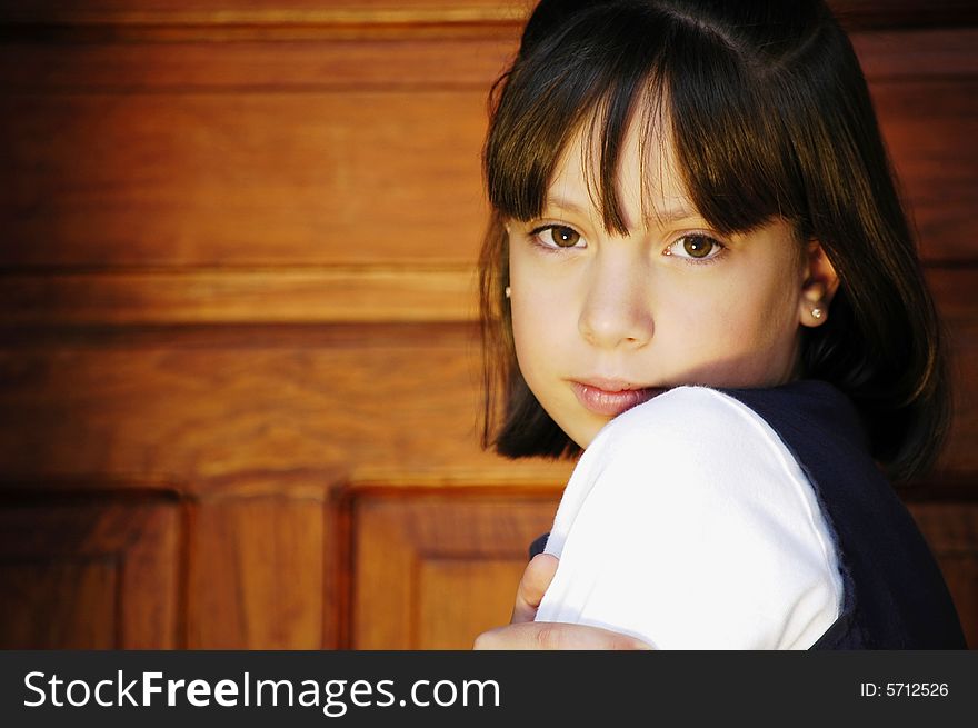 Girl infront of a door looking forward over her shoulder. Girl infront of a door looking forward over her shoulder