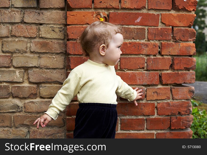 An image of  little girl near a brick wall. An image of  little girl near a brick wall