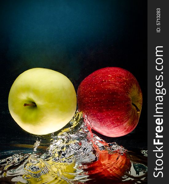 Fresh apple in water on a black/blue background with air bubbles