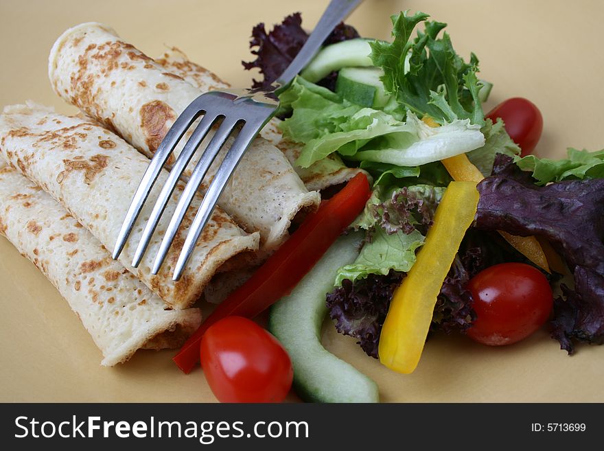 Fresh Salad and pancakes with a fork. Fresh Salad and pancakes with a fork